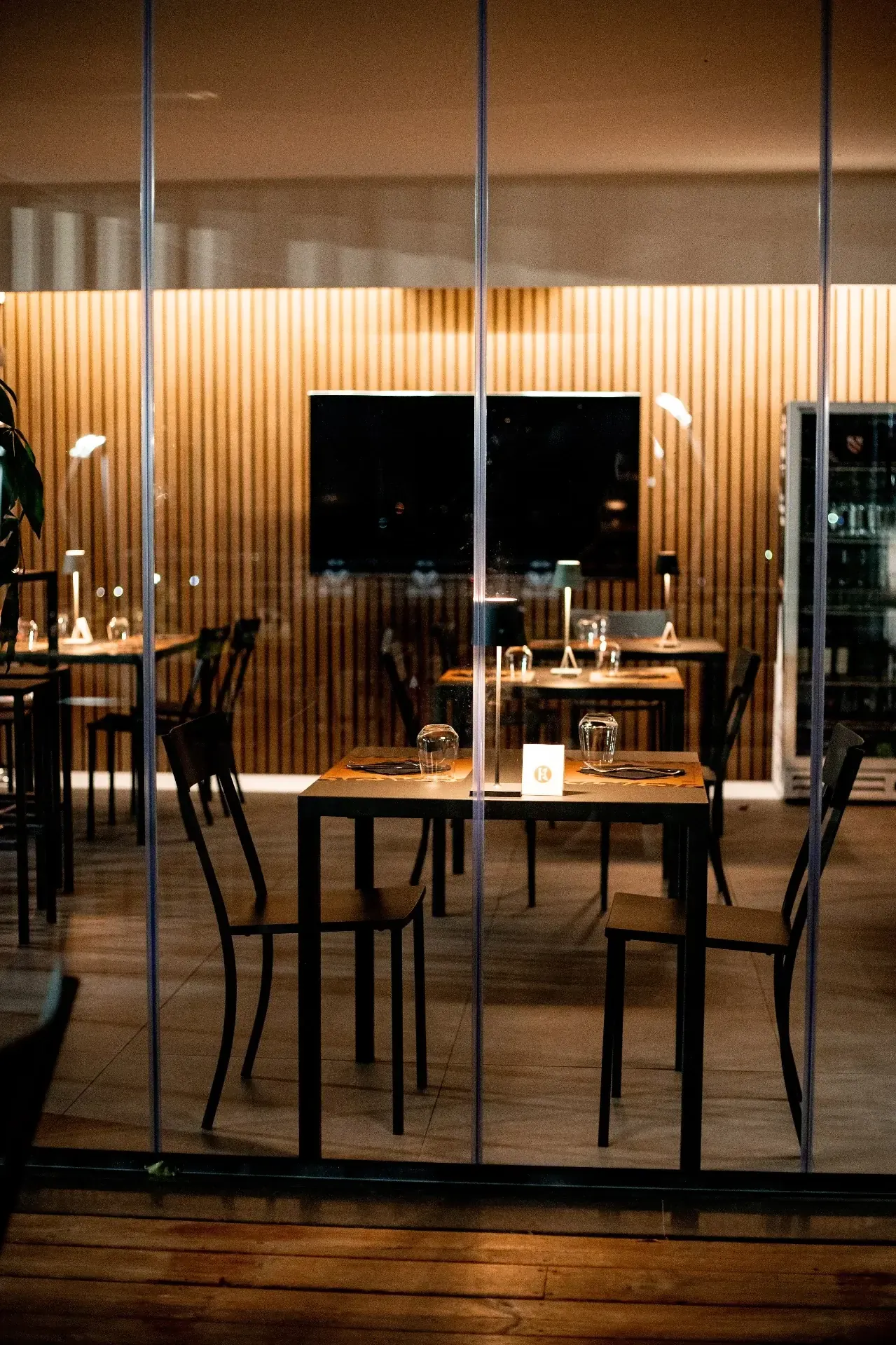 Sala interna Koura con atmosfera calda e tavoli apparecchiati